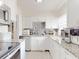 A well-lit kitchen showcasing white cabinets, granite countertops, a tile backsplash, and stainless steel appliances at 8101 Dominguin St, Orlando, FL 32817