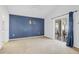 Bedroom boasts a blue accent wall, sliding doors, and neutral carpet at 8103 Yellow Crane Dr, Kissimmee, FL 34747