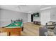 Spacious game room with a pool table, TV, comfortable seating, and wood-look floors at 8103 Yellow Crane Dr, Kissimmee, FL 34747