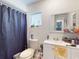 Cozy bathroom featuring a single sink vanity, toilet, and shower with curtain at 830 E Flag Ln, Kissimmee, FL 34759