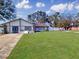 Inviting single-story home featuring a lush green lawn, stone accents, and bright blue front door at 830 E Flag Ln, Kissimmee, FL 34759