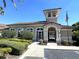 Exterior of the clubhouse featuring a tower and a gated entrance with a wheelchair access symbol at 8766 The Esplanade # 23, Orlando, FL 32836