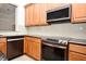 Close-up of a modern kitchen with wood cabinets and stainless steel appliances at 8766 The Esplanade # 23, Orlando, FL 32836