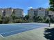 Community tennis court with tennis net and apartment buildings in the background at 8766 The Esplanade # 23, Orlando, FL 32836