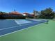 Community tennis court with a visible net, lined in blue and green at 8766 The Esplanade # 23, Orlando, FL 32836