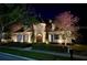 Elegant home exterior with manicured landscaping and illuminated by landscape lighting at dusk at 885 Spring Park Loop, Celebration, FL 34747