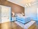 This main bedroom showcases a decorative accent wall, chandelier, and an ensuite bathroom with standalone tub at 885 Spring Park Loop, Celebration, FL 34747