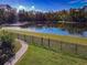 Picturesque pond framed by a black fence and lush greenery at 885 Spring Park Loop, Celebration, FL 34747