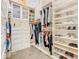 This organized walk-in closet features built-in shelving, drawers, and rods for clothing and accessories at 885 Spring Park Loop, Celebration, FL 34747