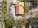 An aerial view displays a home with a metal roof surrounded by a mix of trees and vehicles at 901 W Donegan Ave, Kissimmee, FL 34741