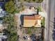 An aerial view displays a home with a metal roof, adjacent street, and some surrounding landscaping at 901 W Donegan Ave, Kissimmee, FL 34741