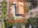 An aerial view displays a home with a metal roof surrounded by a mix of trees and vehicles at 901 W Donegan Ave, Kissimmee, FL 34741