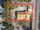 An aerial view displays a home with a metal roof, adjacent street, and some surrounding landscaping at 901 W Donegan Ave, Kissimmee, FL 34741