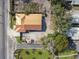 An aerial view displays a home with a metal roof, adjacent street, and some surrounding landscaping at 901 W Donegan Ave, Kissimmee, FL 34741