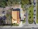 An aerial view displays a home with a metal roof, adjacent street, and some surrounding landscaping at 901 W Donegan Ave, Kissimmee, FL 34741