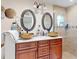 Bathroom featuring double sinks, decorative mirrors, and a glass-enclosed shower at 901 W Donegan Ave, Kissimmee, FL 34741