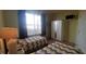 Bright bedroom with two twin beds, large window, wardrobe, and mounted television at 991 Lake Berkley Dr, Kissimmee, FL 34746