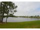 Scenic view of a lake surrounded by well-maintained lawns and houses in the distance at 991 Lake Berkley Dr, Kissimmee, FL 34746