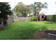 Large backyard boasts a green lawn, wood fence, mature trees, and convenient storage shed at 1013 Illinois Ave, St Cloud, FL 34769