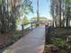 Picturesque wooden boardwalk leading to a covered dock on the water, surrounded by lush landscaping at 10210 Hartford Maroon Rd, Orlando, FL 32827