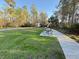 Community picnic area featuring a table on a grassy lot alongside a paved walking trail on a sunny day at 10210 Hartford Maroon Rd, Orlando, FL 32827