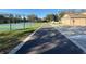 View of tennis court adjacent to community homes with an asphalt walking path and manicured lawns at 10210 Hartford Maroon Rd, Orlando, FL 32827