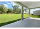 A covered back porch overlooking a spacious yard with green lush grass and clear skies at 1111 Olivine Ave, Dundee, FL 33838