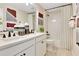 Elegant bathroom with a double vanity, black hardware, neutral color palette and a tub-shower with a plaid curtain at 1111 Olivine Ave, Dundee, FL 33838