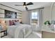 Cozy bedroom featuring a ceiling fan, comfortable bed, striped accent wall and a window offering natural light at 1111 Olivine Ave, Dundee, FL 33838