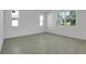 Spacious bedroom with ample natural light from multiple windows and wood-look tile flooring at 1111 Olivine Ave, Dundee, FL 33838