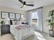 Comfortable bedroom featuring a ceiling fan, natural light from window, stylish decor, and black nightstands at 1111 Olivine Ave, Dundee, FL 33838