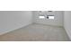 A bright bedroom with plush carpeting, white walls, and large windows at 1111 Olivine Ave, Dundee, FL 33838