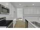 Bright, airy kitchen with stainless appliances, island sink, white cabinets, and wood-look tile flooring at 1111 Olivine Ave, Dundee, FL 33838