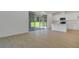 Bright living area with tile flooring, sliding glass doors to a patio, and an open kitchen at 1111 Olivine Ave, Dundee, FL 33838