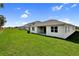 Large backyard with fresh grass, a covered patio, and privacy fence on a sunny day at 1115 Olivine Ave, Dundee, FL 33838