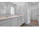 Modern bathroom with double vanity, quartz countertop, and wood-look tile flooring at 1115 Olivine Ave, Dundee, FL 33838
