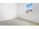 Bright bedroom with carpet flooring and natural light from the large window at 1115 Olivine Ave, Dundee, FL 33838