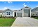 Charming single-story home with a three-car garage and manicured front lawn at 1115 Olivine Ave, Dundee, FL 33838