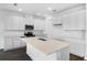 Modern kitchen featuring an island, stainless appliances, and sleek white cabinetry at 1115 Olivine Ave, Dundee, FL 33838