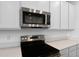 Stainless steel appliances complement the white cabinetry and quartz countertops at 1115 Olivine Ave, Dundee, FL 33838