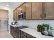 Modern kitchen with stainless steel appliances, white countertops, tile backsplash, and wooden cabinets at 1115 Olivine Ave, Dundee, FL 33838