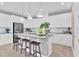 Bright kitchen featuring white cabinets, stainless steel appliances, an island with seating, and modern pendant lighting at 1119 Olivine Ave, Dundee, FL 33838