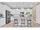 Modern kitchen features white cabinets, stainless steel appliances, an island with seating, and pendant lighting at 1119 Olivine Ave, Dundee, FL 33838