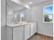 Bathroom with double vanity, large mirror, and a separate glass-enclosed shower at 1127 Olivine Ave, Dundee, FL 33838