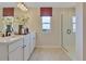 Bathroom featuring a double vanity, a window providing natural light, and a glass-enclosed shower at 1127 Olivine Ave, Dundee, FL 33838