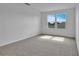 Spacious bedroom with neutral carpet, two sunny windows, and ample natural light at 1127 Olivine Ave, Dundee, FL 33838