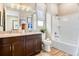 Bathroom features a double vanity, soaking tub with shower, and modern fixtures with wood look floors at 1131 Olivine Ave, Dundee, FL 33838