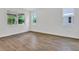 Spacious bedroom showcasing wood-look tile flooring and views of the outdoors through large windows at 1131 Olivine Ave, Dundee, FL 33838