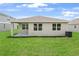 View of rear exterior of home with covered patio and green grass at 1131 Olivine Ave, Dundee, FL 33838
