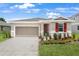Beautifully landscaped home with a neutral color palette and two-car garage, providing both style and functionality at 1131 Olivine Ave, Dundee, FL 33838